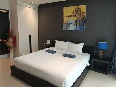 a large white bed with two blue towels on it at Emerald Terrace Condo 3-Studio Garden Gem in Patong Beach