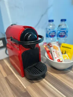 a red appliance sitting on a table with water bottles at Emerald Terrace Condo 3-Studio Garden Gem in Patong Beach