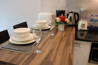 a table with plates and wine glasses on it at Emerald Terrace Condo 3-Studio Garden Gem in Patong Beach