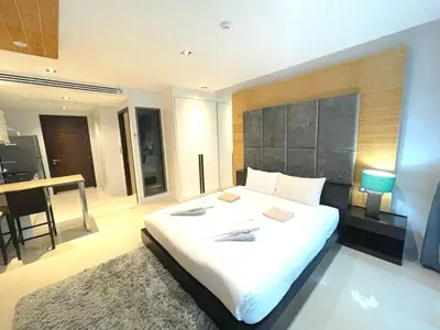 a bedroom with a large white bed and a desk at Emerald Terrace Condo 5-Studio Garden zen in Patong Beach