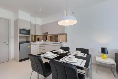 a kitchen with a dining table and chairs and a kitchen with at Cassia Residence Laguna Phuket Holiday Rental Apartment, Bang Tao Beach in Phuket Town