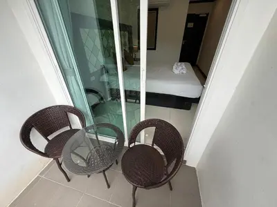 two chairs and a glass table in a room at COZY Residence Patong in Patong Beach