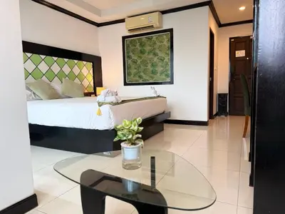 a bedroom with a bed and a glass table at COZY Residence Patong in Patong Beach
