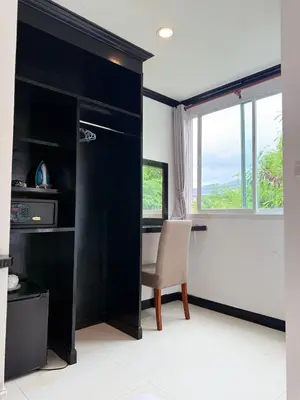 a room with a desk and a chair and a window at COZY Residence Patong in Patong Beach