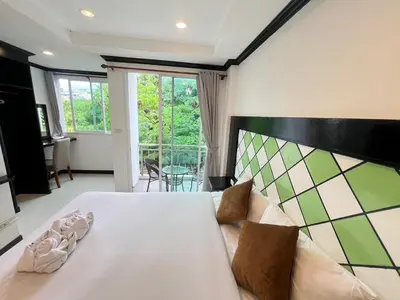 a bedroom with a large white bed and a window at COZY Residence Patong in Patong Beach