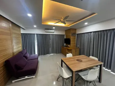a living room with a table and a ceiling fan at Patong Tower Superior Apt 2 bedrooms 2 bathrooms in Patong Beach
