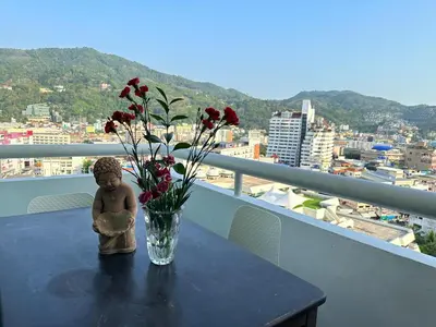 a vase of flowers on a table on a balcony at Patong Tower Superior Apt 2 bedrooms 2 bathrooms in Patong Beach