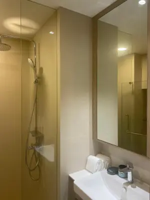 a bathroom with a shower and a sink and a mirror at Modern Golf course view Apartment in Sky Park Laguna in Phuket Town