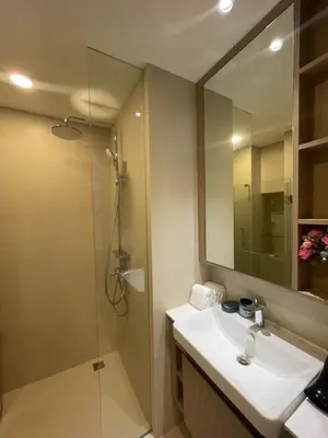 a bathroom with a sink and a shower with a mirror at Modern Golf course view Apartment in Sky Park Laguna in Phuket Town