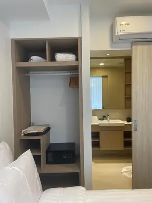a bedroom with a bed and a bathroom with a sink at Modern Golf course view Apartment in Sky Park Laguna in Phuket Town