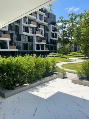 a large apartment building with a garden in front of it at Modern Golf course view Apartment in Sky Park Laguna in Phuket Town