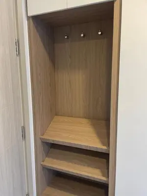 a cupboard with wooden shelves in a closet at Modern Golf course view Apartment in Sky Park Laguna in Phuket Town