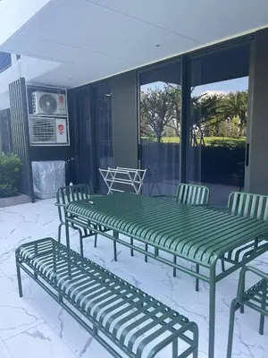a green table and chairs on a patio at Modern Golf course view Apartment in Sky Park Laguna in Phuket Town