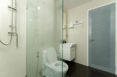 a bathroom with a toilet and a glass shower at Kamala family friendly pool villa by Lofty in Kamala Beach