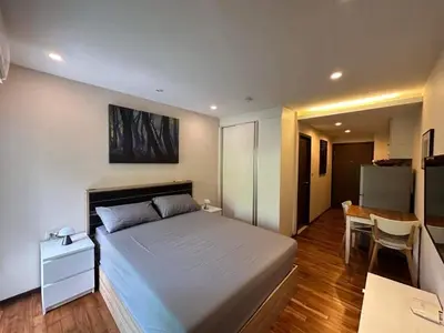 a bedroom with a bed and a table and a kitchen at Studio Title III, Rawai Phuket in Rawai Beach