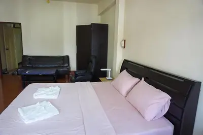 a bedroom with a bed with two pink pillows at Sonya Residence in Patong Beach