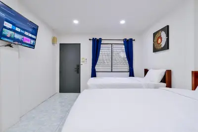 two beds in a room with a tv on the wall at GP House Krabi Aonang Beach in Ao Nang Beach