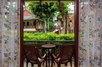 a balcony with chairs and a table and a building at Anyavee Aonang Bay in Ao Nang Beach