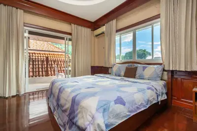 a bedroom with a bed and a window with a view at Cheeva Pool Villa Phuket in Phuket Town