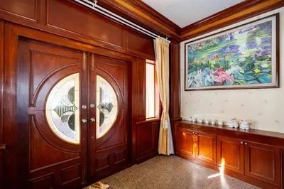 a room with a wooden door and a painting on the wall at Cheeva Pool Villa Phuket in Phuket Town