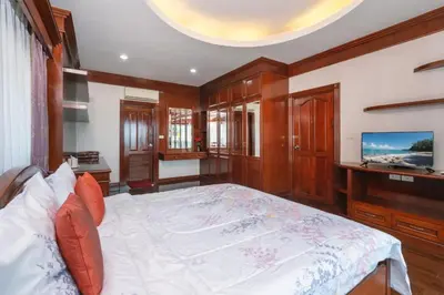 a bedroom with a large bed and a tv at Cheeva Pool Villa Phuket in Phuket Town