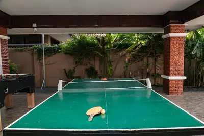 a green ping pong table with a paddle on it at Cheeva Pool Villa Phuket in Phuket Town