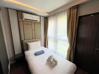 a hotel room with a bed with a pair of gloves on it at Luxury sea view apartment at Mida Grande in Surin Beach