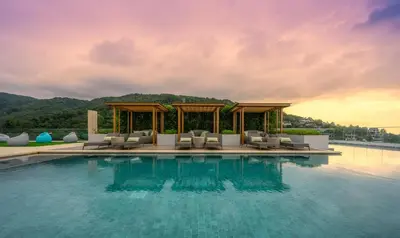 a pool at a resort with chairs and a gazebo at Luxury sea view apartment at Mida Grande in Surin Beach