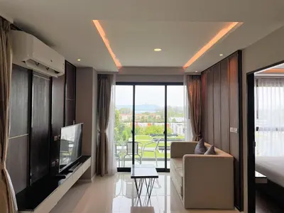 a bedroom with a couch and a tv in a room at Luxury sea view apartment at Mida Grande in Surin Beach