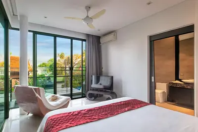 a bedroom with a bed and a chair and a balcony at Villa Sabine private pool 4br seaview jacuzzi in Rawai Beach