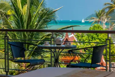 a table and chairs on a balcony with a view of the ocean at Villa Sabine private pool 4br seaview jacuzzi in Rawai Beach