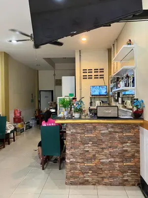 a woman sitting at a bar in a restaurant at Cozy Place in Patong Beach