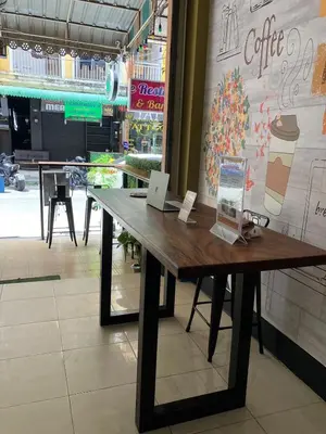 a wooden table in front of a coffee shop at Cozy Place in Patong Beach