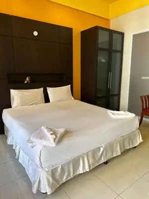 a large bed with white sheets and pillows on it at Cozy Place in Patong Beach
