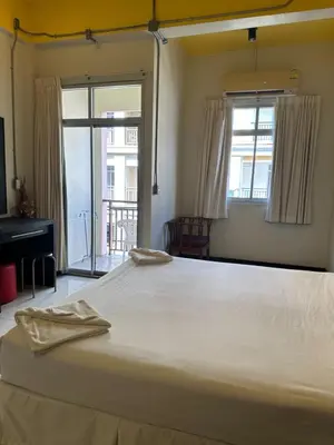 a large white bed in a room with a window at Cozy Place in Patong Beach
