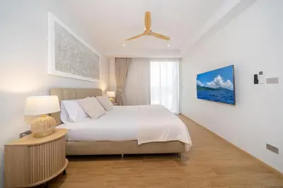 a bedroom with a bed and a ceiling fan at Laguna Beachside 1 bedroom apartment 2 minutes from the beach in Phuket Town