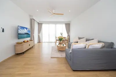 a living room with a couch and a table at Laguna Beachside 1 bedroom apartment 2 minutes from the beach in Phuket Town