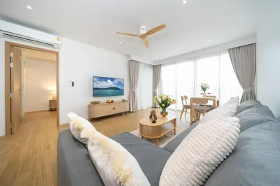 a living room with a blue couch and a table at Laguna Beachside 1 bedroom apartment 2 minutes from the beach in Phuket Town