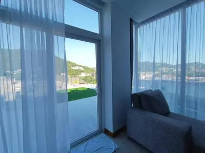 a room with a chair and a large window with a view at Smart Conzept 2bdr 300m to the sea in Kata Beach