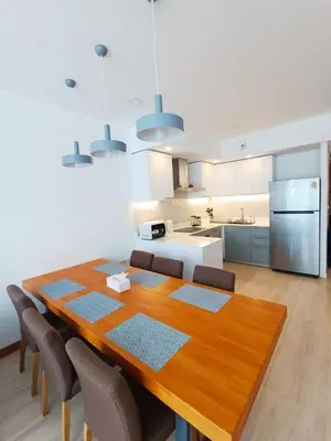 a kitchen and dining room with a wooden table and chairs at Smart Conzept 2bdr 300m to the sea in Kata Beach