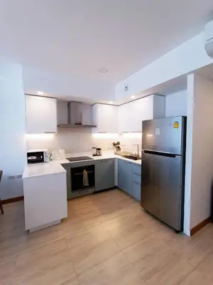 a kitchen with a stainless steel refrigerator and white cabinets at Smart Conzept 2bdr 300m to the sea in Kata Beach