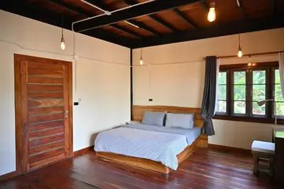 a bedroom with a bed and a wooden door at The Moonlight Guesthouse in Patong Beach