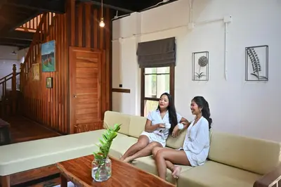 two women sitting on a couch in a living room at The Moonlight Guesthouse in Patong Beach