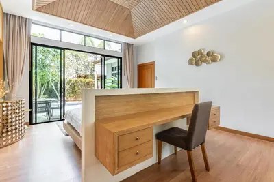 a bedroom with a desk and a bed with a window at Tanode Villa 511 by Villacarte in Bang Tao Beach