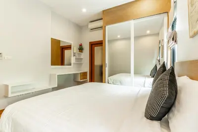 a bedroom with a large white bed and a mirror at Tanode Villa 511 by Villacarte in Bang Tao Beach