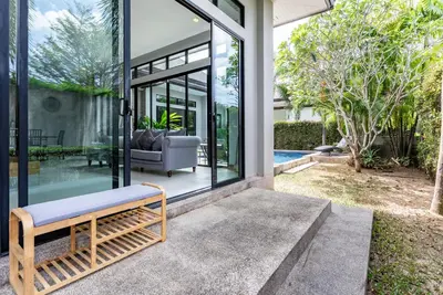 a bench sitting on the front of a house at Tanode Villa 511 by Villacarte in Bang Tao Beach