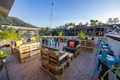 a patio with chairs and tables on a roof at Club22 Kamala Suites, Kamala Beach in Kamala Beach