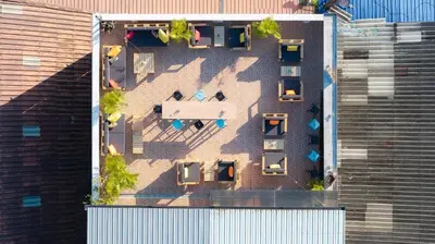an aerial view of a building with chairs and tables at Club22 Kamala Suites, Kamala Beach in Kamala Beach