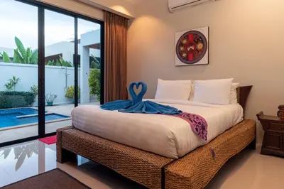a bedroom with a bed with a blue towel on it at Andaman 3br Private Pool Villa in Rawai Beach