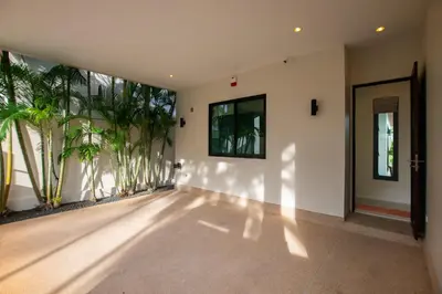 an empty room with a hallway with palm trees at Andaman 3br Private Pool Villa in Rawai Beach